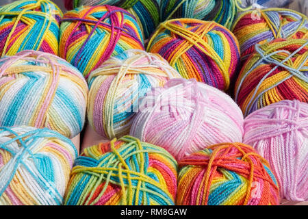 Balls of rainbow coloured and pink wools Stock Photo