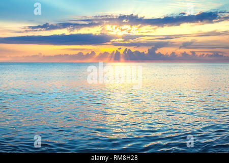 beautiful sea landscape with a sunset. evening sky with clouds and sunshine over ocean. sun rays shine break through clouds Stock Photo