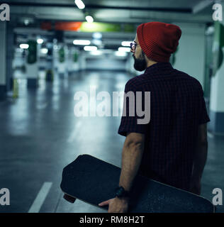 Rear view of skateboarder holding his longboard Stock Photo