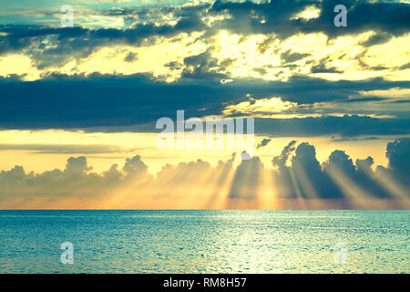 beautiful sea landscape with a sunset. evening sky with clouds and sunshine over ocean. sun rays shine break through clouds