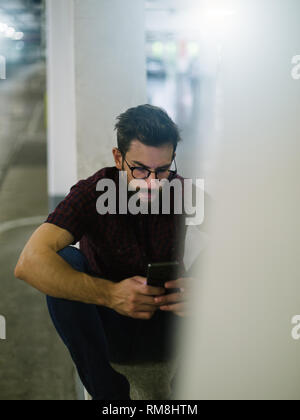 Hipster skater using smart phone in underground Stock Photo