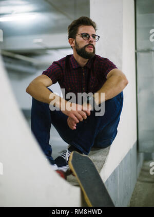 Hipster skater using smart phone in underground Stock Photo