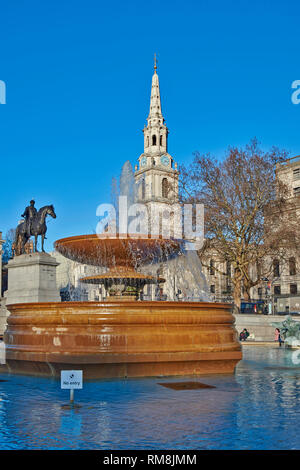 LONDON TRAFALGAR SQUARE A FOUNTAIN AND THE SPIRE OF ST MARTIN IN THE FIELDS Stock Photo
