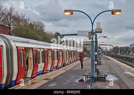 LONDON UNDERGROUND OR TUBE TRAIN  AT A STATION  DOORS OPEN AND PASSENGER ON THE PLATFORM Stock Photo