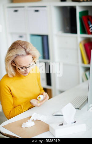 Woman Taking Pills at Workplace Stock Photo