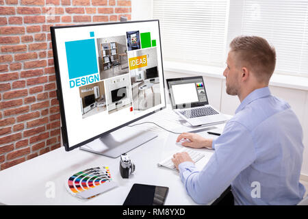 Male Designer Using Graphic Tablet While Working On Computer Stock Photo