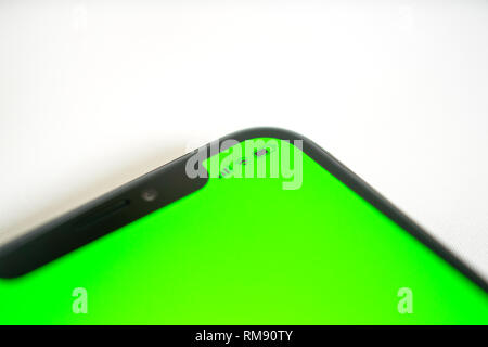 Side view detail of smartphone detail with chroma green screen and icons for the current hour, battery charge wi-fi and network lte signal Stock Photo
