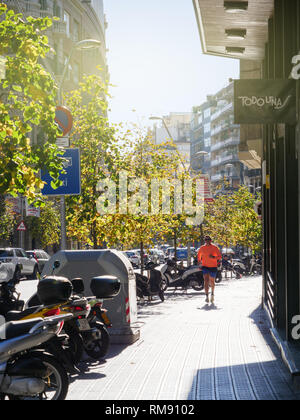 Barcelona, Spain - Nov 12, 2017: Front view of adult runner on the Barcelona street early in the morning - perspective view  Stock Photo
