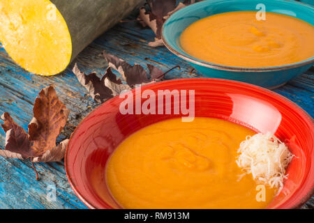 Pumpkin soup with cheerse. Pumpkin cream, two plates on a rustic blue wooden table Stock Photo
