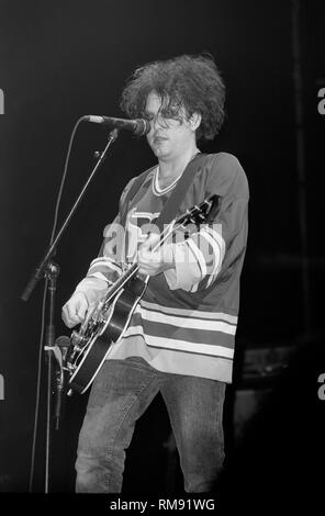 Singer, songwriter and guitarist Robert Smith is shown performing onstage during a 'live' concert appearance with The Cure. Stock Photo