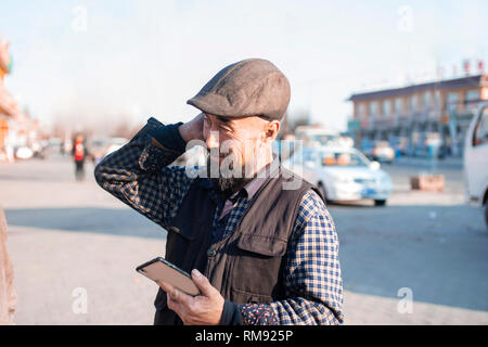 Using mobile phone Asian lod man. Stock Photo