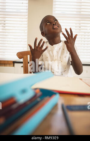 African American boy doing homework on dining table in kitchen Stock Photo
