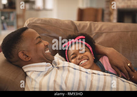 Happy African American father and daughter relaxing on the sofa Stock Photo