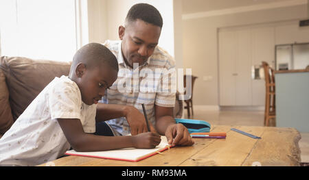 African American father helping his son with homework at table Stock Photo