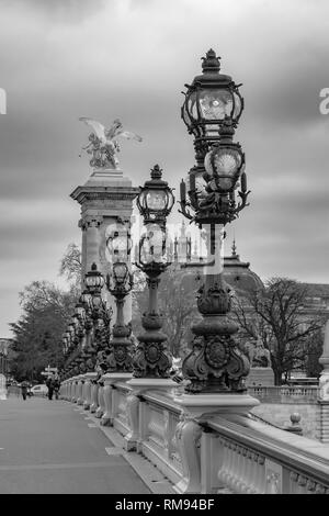 Moody cityscape with Pont Alexandre III bridge and Seine river and Eiffel Tower in Paris, France in black and white treatment Stock Photo