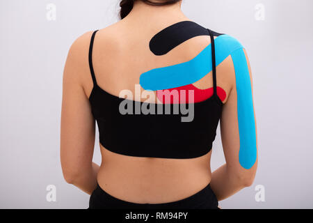 Rear View Of Woman In Wearing Sportswear With Physio Tape Stock Photo