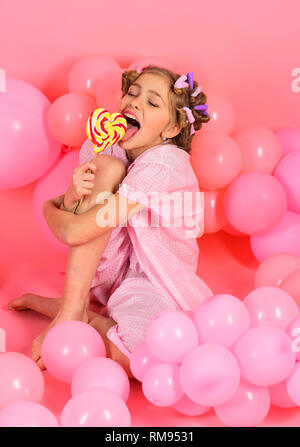 Party balloons, kid in curlers, pajama fashion. Stock Photo