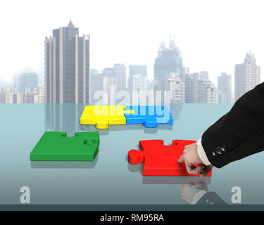 Assembling four puzzles on table in office Stock Photo
