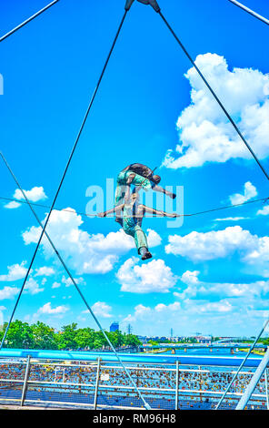 KRAKOW, POLAND - JUNE 21, 2018: The sculpture of the acrobats, mounted on the construction of the Father Bernatek Footbridge, on June 21 in Krakow. Stock Photo