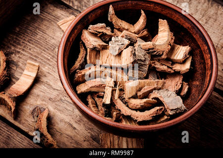Oak bark in bowl on dark wooden table. Oak in herbal medicine.Herbs medicine Stock Photo