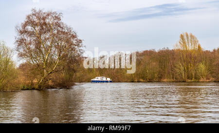 Near Wroxham, Norfolk, England, UK - April 07, 2018: A boat on the River Bure in The Broads Stock Photo