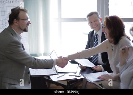 handshake business women and business men near the desktop Stock Photo