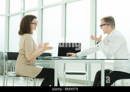 two employees discuss work issues at the office Desk Stock Photo
