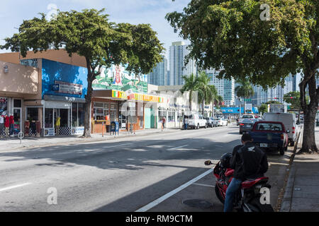 A man sits on a motorcycle by the side of SW 8th street in Miami, Florida, USA Stock Photo