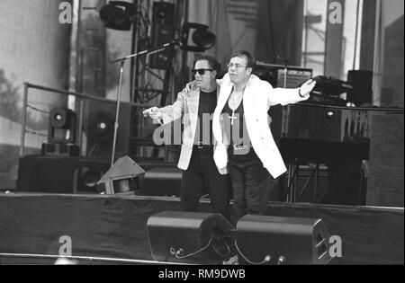 Musicians Billy Joel and Elton are shown performing on stage together during a very special 'live' concert appearance. Stock Photo