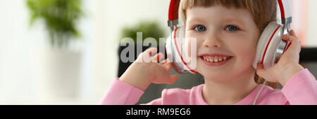 Satisfied child in headphones sitting Stock Photo