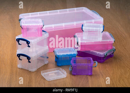 Plastic storage boxes or crates on a wooden table. Stock Photo