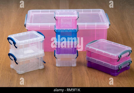 Plastic storage boxes or crates on a wooden table. Stock Photo