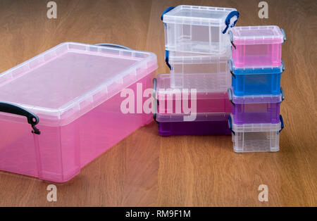 Plastic storage boxes or crates on a wooden table. Stock Photo