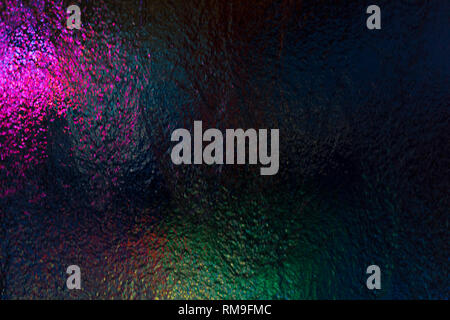 Water flow on glass with colored light show from behind Stock Photo