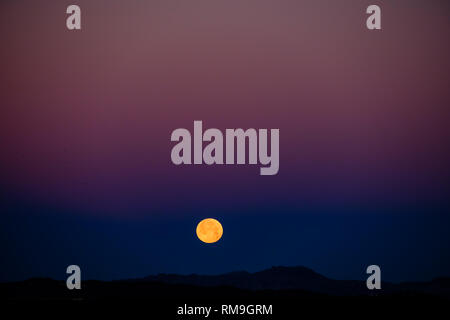 Moonset, a super blood red wolf moon over the El Torcal mountains Stock Photo