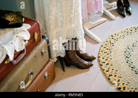 Vintage dressing room with old clothes, handmade lace dresses, leather model shoes, hand-woven carpet of cloth strips, suitcases with snaps - an illus Stock Photo