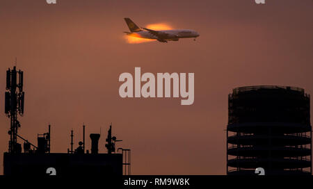 Frankfurt am Main, Germany. 07th Jan, 2016. A Lufthansa Airbus A380 coming in to land at the airport in Frankfurt am Main, Germany, 07 January 2016. The morning light illuminates the vapour around the plane. The new building of the Henninger Turm tower can be seen at bottom right. PHOTO: FRANK RUMPENHORST/DPA | usage worldwide Credit: dpa/Alamy Live News Stock Photo