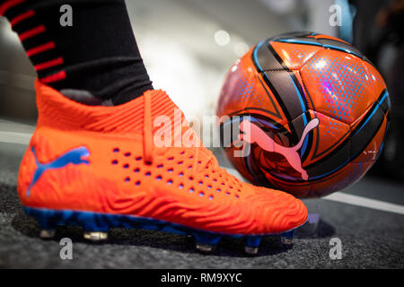 14 February 2019, Bavaria, Herzogenaurach: A football and a football shoe with the logo of the sporting goods manufacturer Puma SE stand are exhibited in the company. On 14 February, the sporting goods manufacturer will present its balance sheet for the year 2018. Photo: Daniel Karmann/dpa Stock Photo