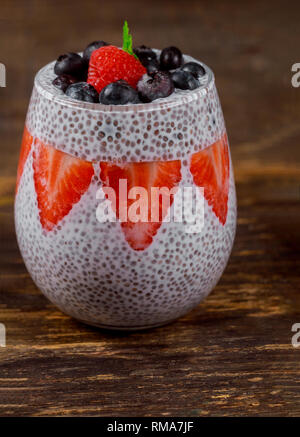 Chia Pudding with decorated with ripe strawberry in transparent glasses