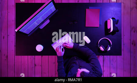 Young man programmer or hacker working on computer at night. Stock Photo
