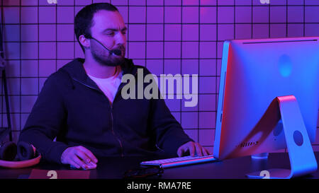 Young man programmer or hacker working on computer at night. Stock Photo