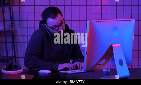 Professional hacker using mobile cell phone talking and spreading bad data virus online. Stock Photo