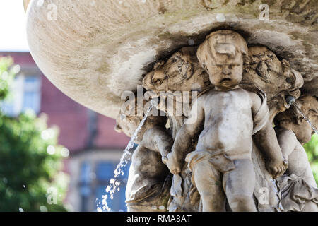 BIRMINGHAM, UK - March 2018 CloseUp of Fountain made of Stone with Children Holding Hands Supporting Basin on their Heads. Water Pouring Out of Animal Stock Photo