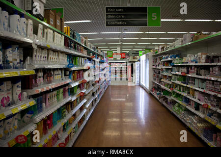 BIRMINGHAM, UK - March 2018 ASDA Aisle of Toiletries in Supermarket. Red Sale Tags on Selected Items. Glossy Floor Reflecting the Light. Personal Care Stock Photo
