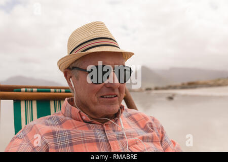Senior man listening music on earphones while relaxing Stock Photo