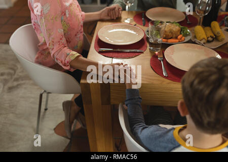 Family praying together before having meal on dining table Stock Photo