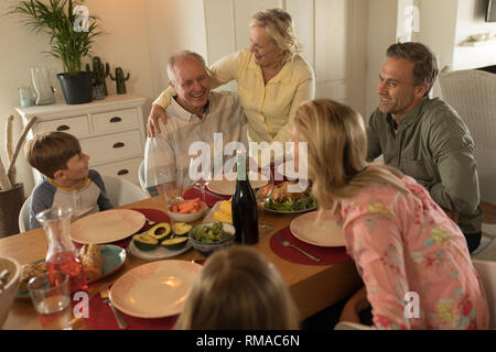 Family interacting with each other while having meal Stock Photo