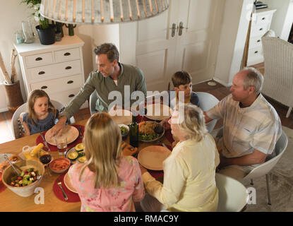 Family interacting with each other while having meal Stock Photo