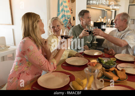 Family toasting glasses of wine on dining table Stock Photo