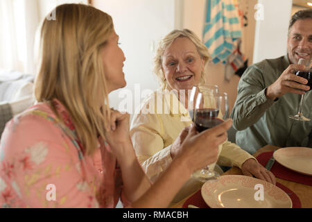 Family toasting glasses of wine on dining table Stock Photo